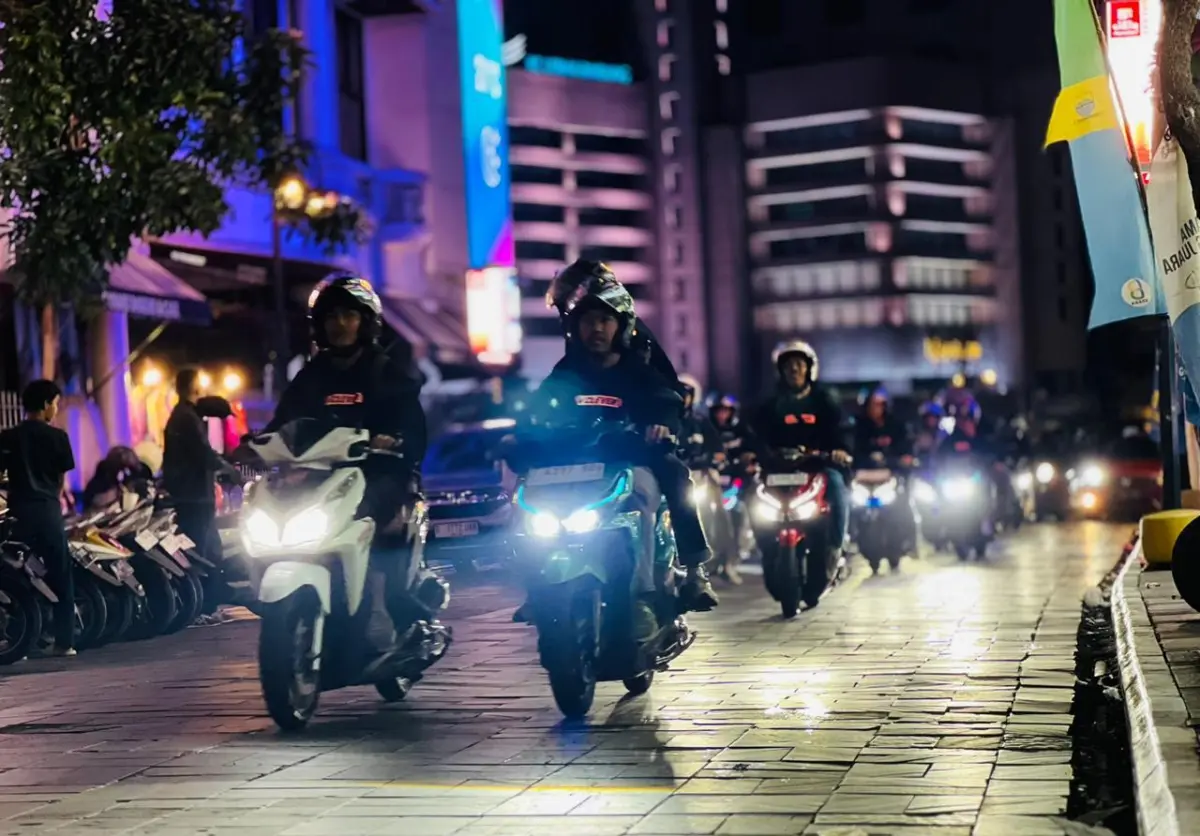 foto ilustrasi pengendara sepeda motor melintasi jalan kota pada malam hari