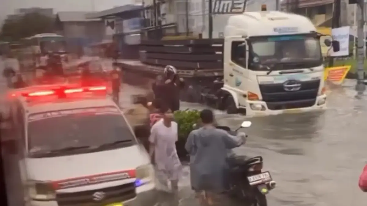 Pengendara motor mendorong kendaraan saat banjir menggenangi Jalan Raya Imam Bonjol, Telagamurni, Cikarang Bar