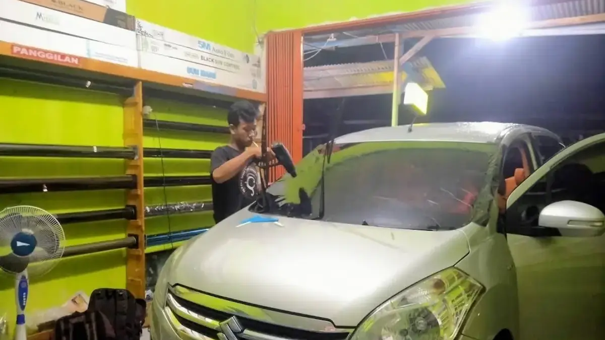 Ilustrasi pemasangan kaca film mobil.