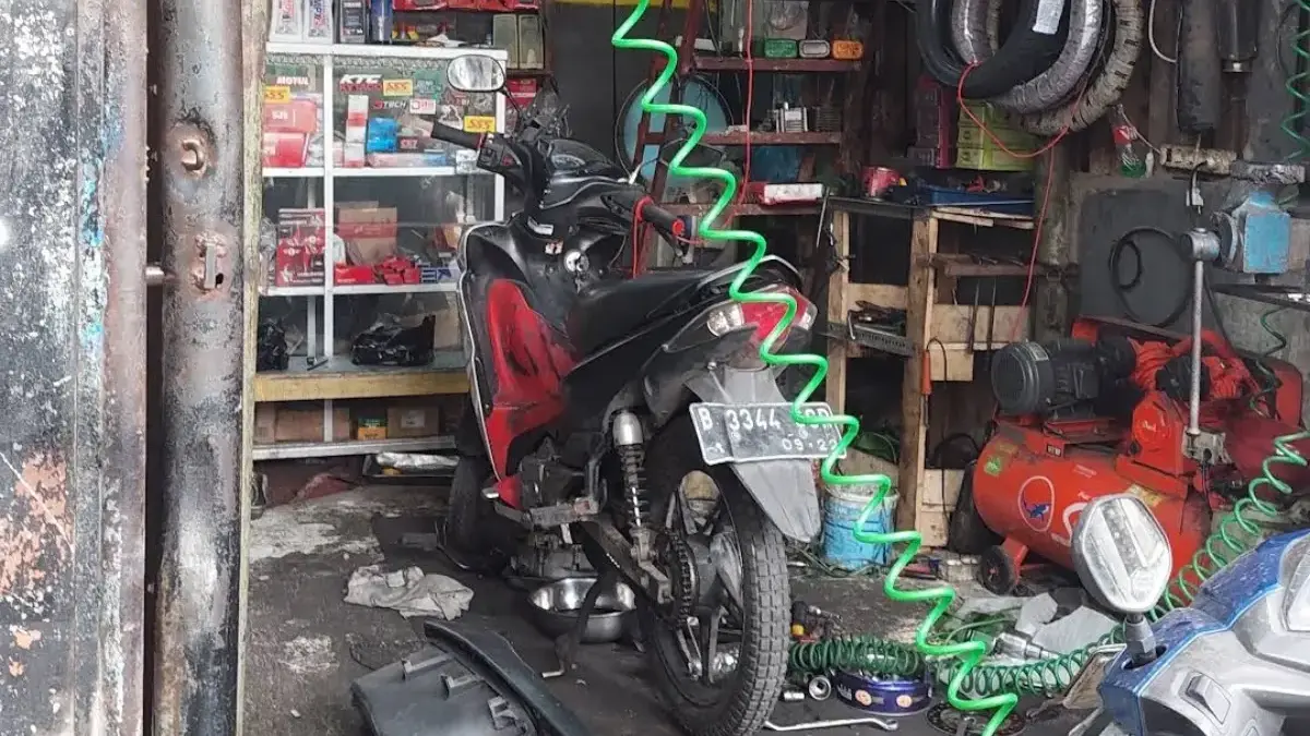 Ilustrasi mekanik sedang melakukan pemeriksaan kendaraan di bengkel umum.
