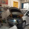 Ilustrasi pemeriksaan mobil di bengkel setelah perjalanan jauh.