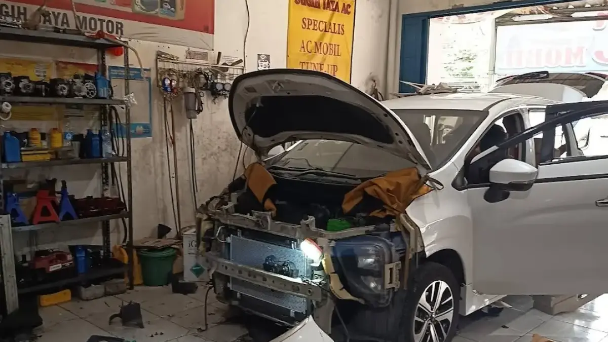 Ilustrasi pemeriksaan mobil di bengkel setelah perjalanan jauh.