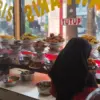 Sepiring nasi Padang lengkap dengan rendang, sayur daun singkong, gulai nangka dan sambal hijau.
