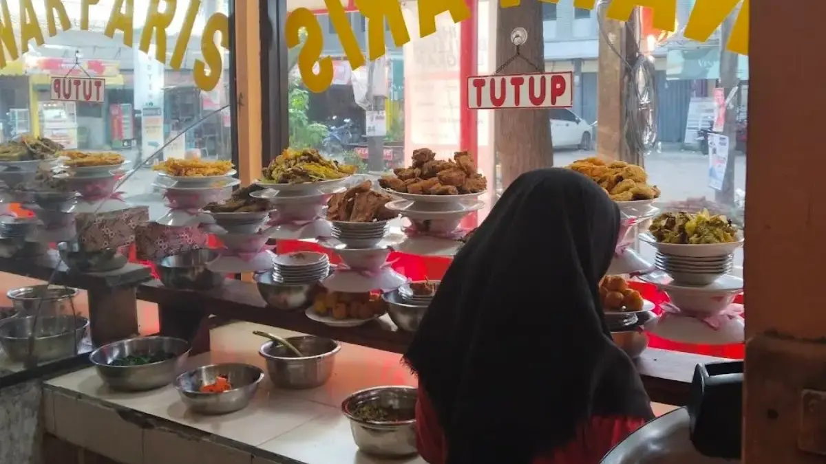 Sepiring nasi Padang lengkap dengan rendang, sayur daun singkong, gulai nangka dan sambal hijau.