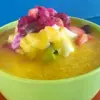 Semangkuk sop buah berisi aneka potongan buah segar dengan kuah manis.