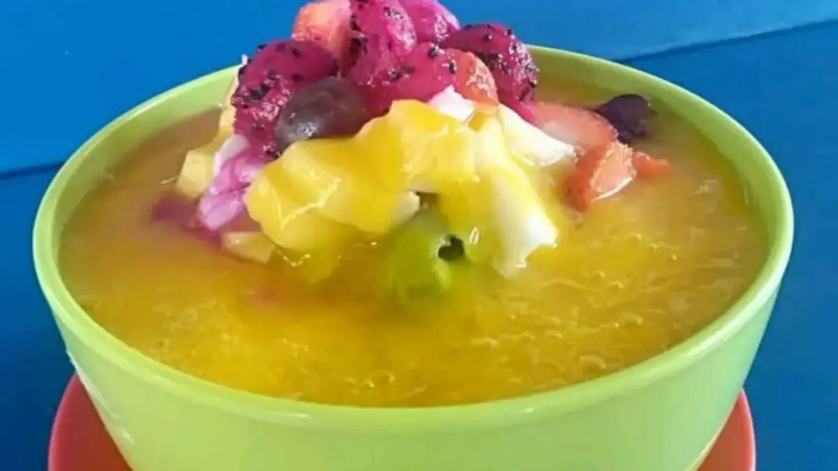 Semangkuk sop buah berisi aneka potongan buah segar dengan kuah manis.