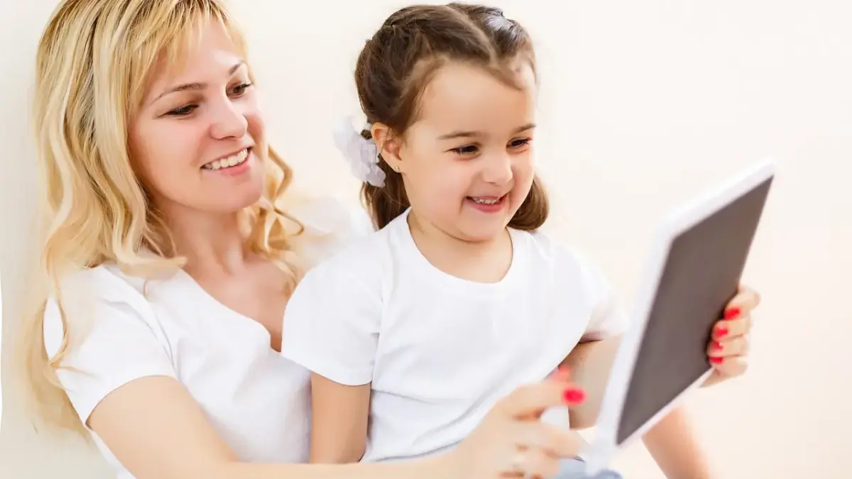 Jangan Asal Kasih! Ini 11 Tips Mendampingi Anak Bermain Aplikasi Digital agar Terhindar dari Kecanduan Gadget Ilustrasi orang tua mendampingi anak menggunakan tablet di rumah.