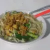 Semangkuk mie yamin dengan tekstur mie kenyal, bumbu manis gurih.