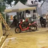 Ilustrasi aktivitas mencuci sepeda motor menggunakan layanan steam.