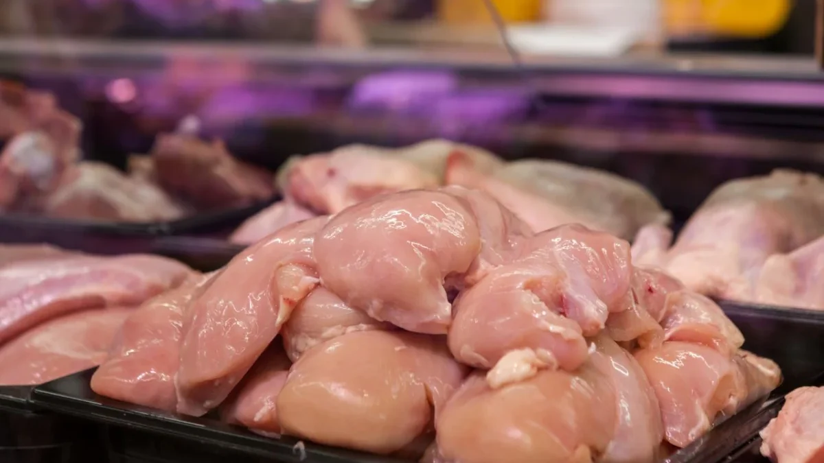 Ilustrasi daging ayam mentah yang disimpan di dalam wadah terbuka.